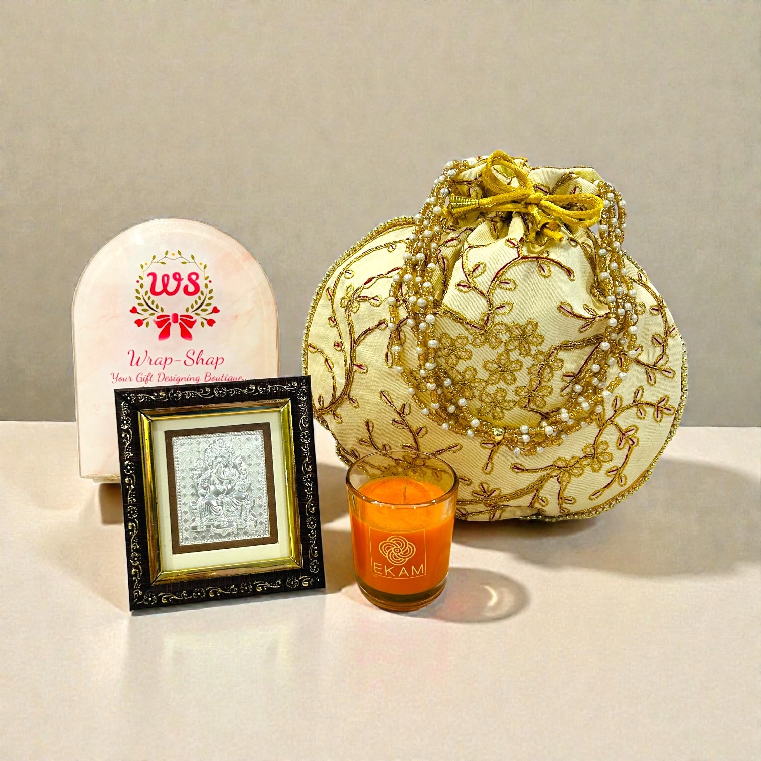 Wedding return gift hamper with Ganesh silver frame, scented candle and pearl chain batwa.