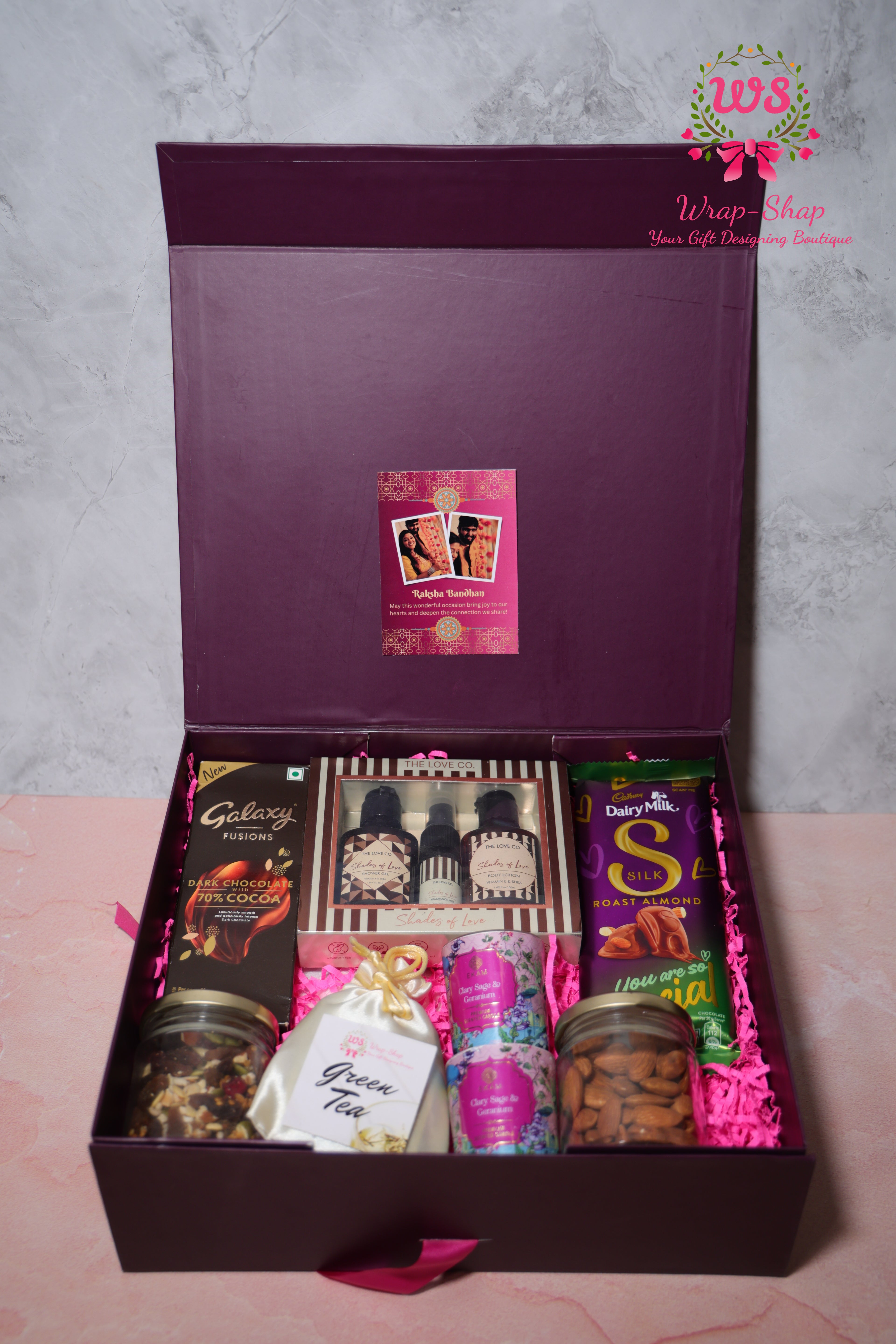 Luxury Bhaiya Bhabhi Rakhi Hamper by Wrap Shap with Love Co body mist, lotion, shower gel, scented candles, almonds, mixed nuts, chocolates, personalized tag, and Rakhi set