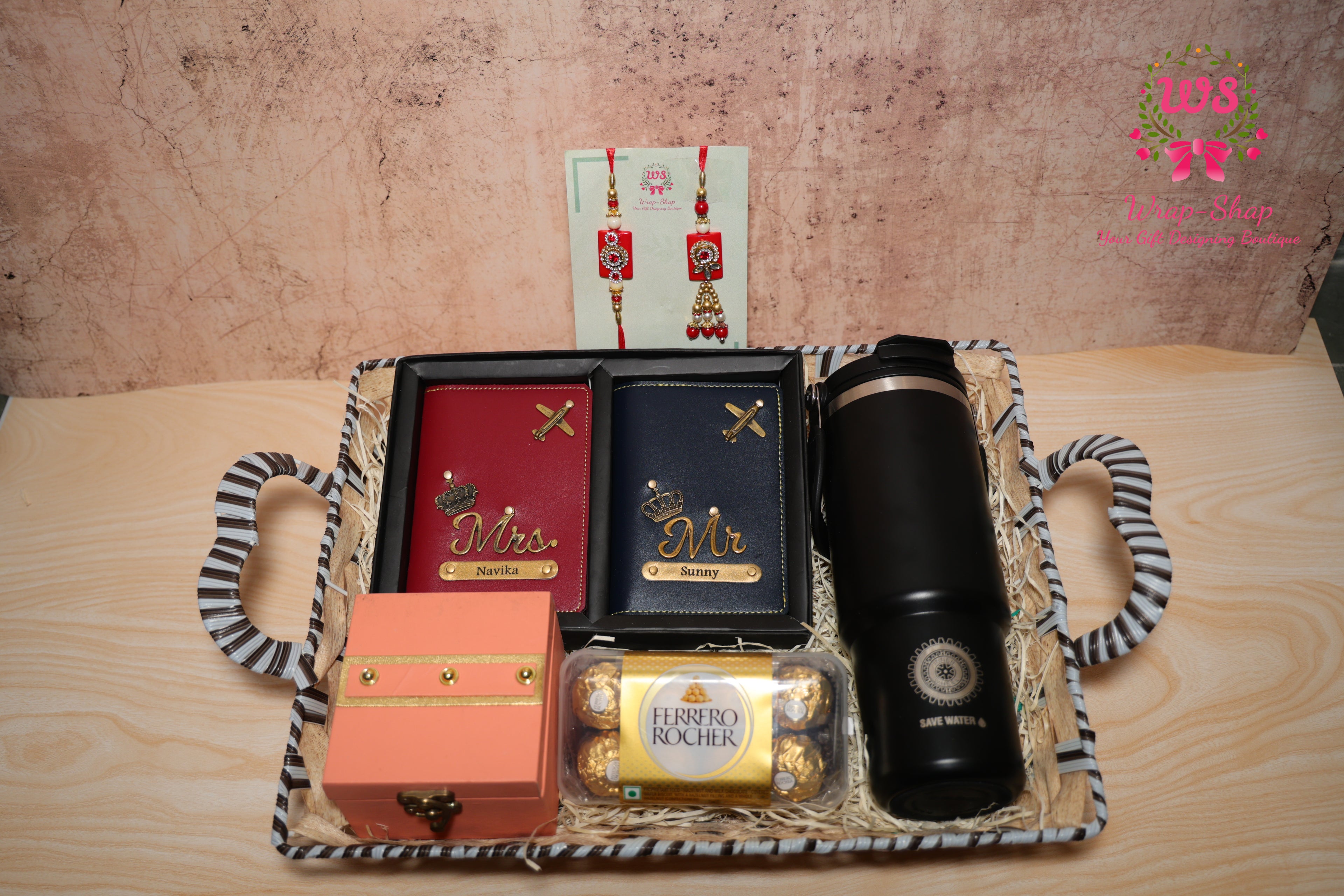 Rakhi hamper with personalized couple passport covers, Ferrero Rocher chocolates, reusable flask, and Bhaiya Bhabhi Rakhi in gift basket by Wrap Shap