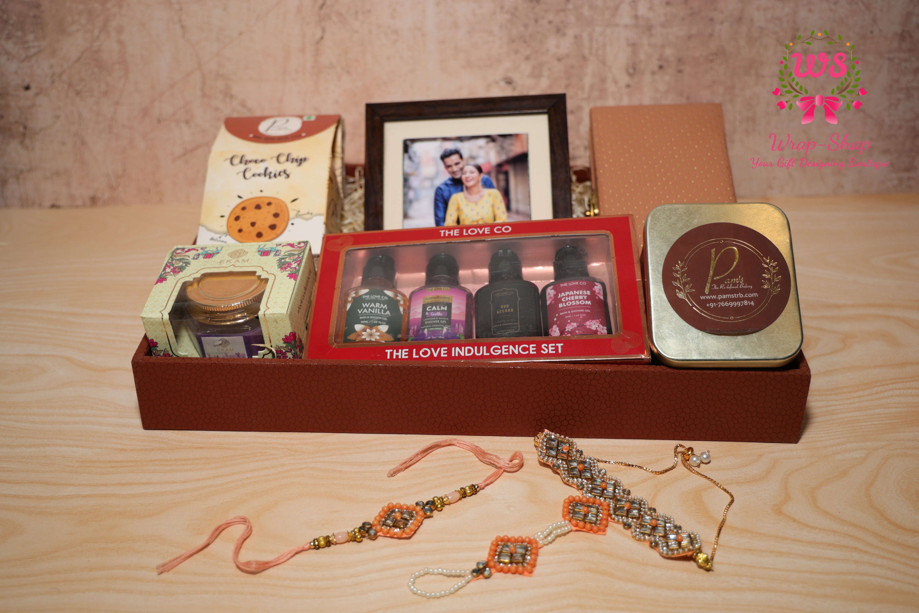 Luxury Rakhi gift hamper for Bhaiya Bhabhi with shower gel set, cookies, chocolates, photo frame, scented candle and Rakhi set in a leather tray by Wrap Shap