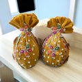 Decorated fresh nariyal wrapped in yellow velvet with booti design for haldi and pooja by Wrap Shap