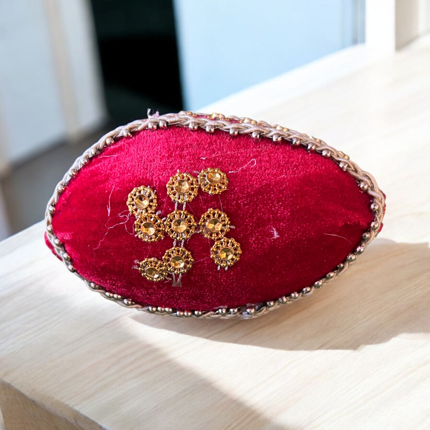 Red cloth wrapped dry coconut (sookha nariyal) with golden Swastik symbol for pooja, griha pravesh, and shagun by Wrap Shap
