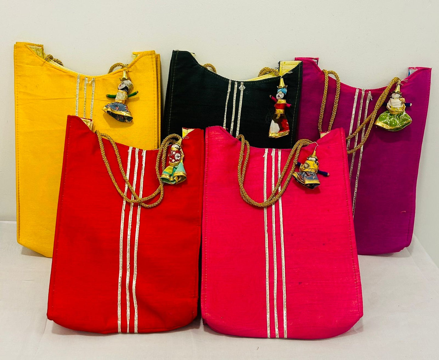 Ethnic gifting bag with Rajasthani puppet hanging in assorted festive colors for weddings and festivals by Wrap Shap